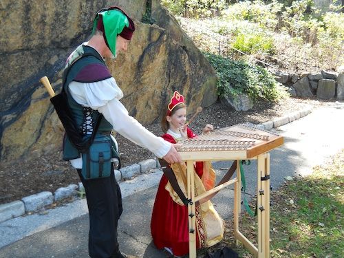 Stephen Starensier offers hammer dulcimer lessons to one of the day's many princesses